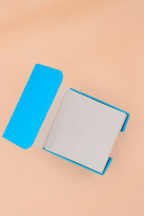 A pack of white post-it in blue a blue box on isolated background.