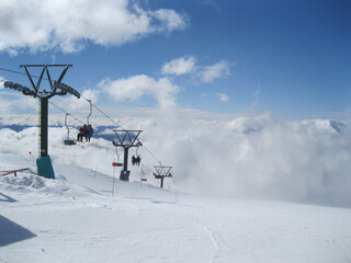 Telesillas y nubes en la cumbre del cerro Catedral