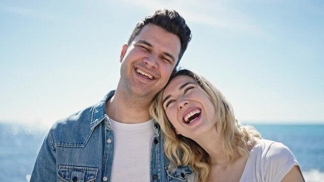 Man and woman couple smiling confident standing together at seaside
