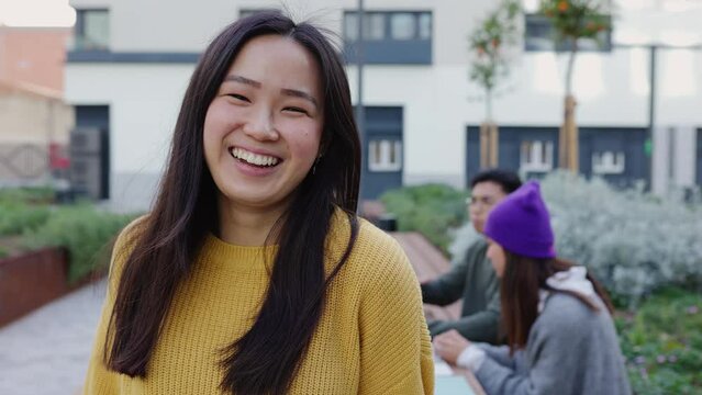 Portrait of young student asian woman smiling at camera sitting at college campus. Education, chinese people and positive emotion concept. 