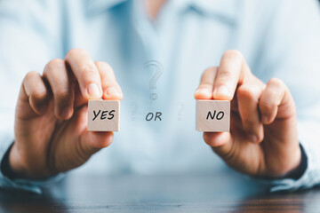 Concept of choice yes or no on wooden cubic blocks. Think with Yes or No choice, Business choices for difficult situations, Business woman hands holding two wooden with yes or no word on it.