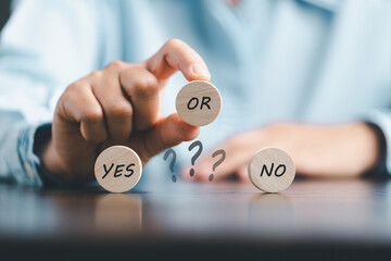 Concept of choice yes on wooden cubic blocks. Think with Yes or No choice, Business choices for difficult situations, Business woman hands with wooden with yes word on it.
