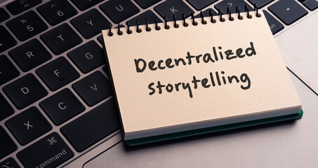 There is note book with the word Decentralized Storytelling on a laptop. It is an eye-catching image.