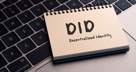 There is note book with the word DID  (Decentralized Identity)  on a laptop. It is an eye-catching image.