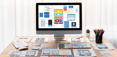 Digital and paper wireframe designs for web or mobile app UI UX display on laptop computer screen. Panoramic shot of developer workspace for brainstorming and design application framework. Scrutinize