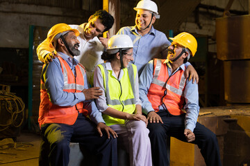 Group of happy cheerful Indian engineers or construction workers at industrial factory having fun...