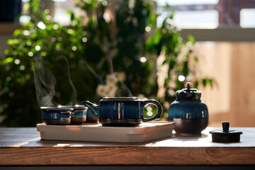 Tea set of deep blue color on a background of greenery.