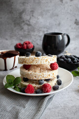 Rice cakes with berries and chocolate. Deliciously. A snack On a gray background
