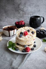 Rice cakes with berries and chocolate. Deliciously. A snack On a gray background