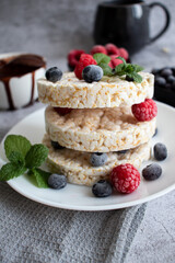 Rice cakes with berries and chocolate. Deliciously. A snack On a gray background