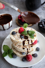 Rice cakes with berries and chocolate. Deliciously. A snack On a gray background