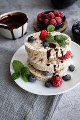 Rice cakes with berries and chocolate. Deliciously. A snack On a gray background
