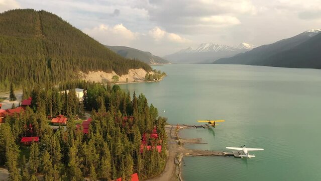 Aerial view, bush planes are parked at the lodge on the lake shore along the Alaska Highway. Travel, adventure, journey concept. Northern Rocky Mountains, Muncho Lake Park, British Columbia, Canada