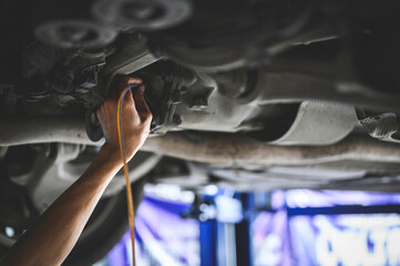 Auto Mechanic filling car rear differential fluid.	
