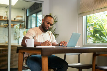 Happy African American man wearing casual clothes working in his home