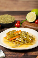 Green bean dish with olive oil on wood background. Close up