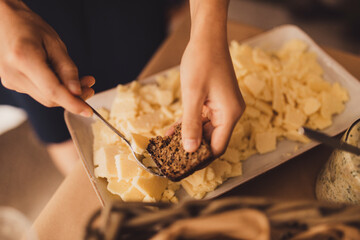 Hands buttering bread at a buffet table.
