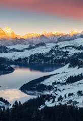 Sunset over Snowy Mountains and Tranquil Lake Reflection