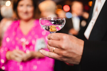 Person holding a glass of martini.