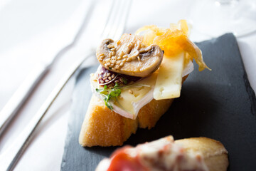 Tapa or skewer. A small slice of bread on which a small portion of food is placed is called a skewer.