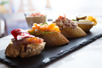 Tapa or skewer. A small slice of bread on which a small portion of food is placed is called a skewer.