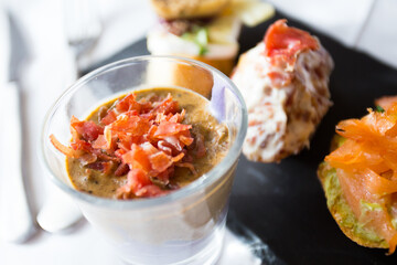 Tapa or skewer. A small slice of bread on which a small portion of food is placed is called a skewer.