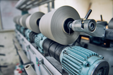 Fototapeta premium An Old industrial stainless steel metal cotton weaving spindle reel, machine weaving cotton for the fashion and textiles industry. Yarn weave traditional textile fabric manufacturing for clothing.