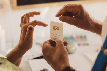 Hands holding a piece of paper with a photo booth challenge symbol printed on.  