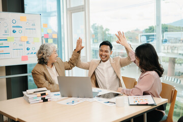Group of Young Asian business team creative businesspeople coworker, teamwork celebrating achievement and in planning design in creative