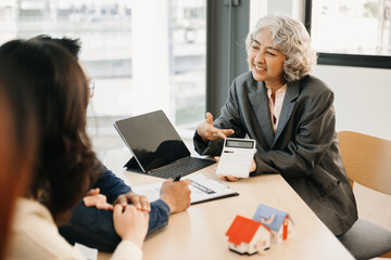 Real estate broker agent presenting and consult to customer to decision making sign insurance form agreement, home model, concerning mortgage loan offer