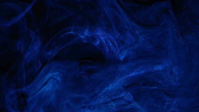 Dark blue paint flowing abstract background. Deep art ink. Shiny blue liquid. Acrylic texture in motion.