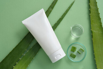Top view of a beaker filled with Aloe vera gel, a petri dish of Aloe vera square shaped slices and...