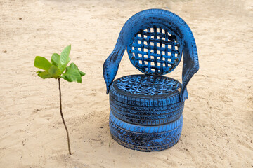 Close up shot of a beach chair made od recycled tyre painted blue. Creative reuse and recycle mood....