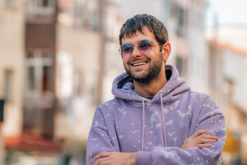 portrait of young man with sunglasses and beard outdoors