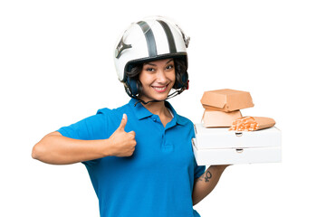 Young Argentinian deliver fast food over isolated background with thumbs up because something good has happened