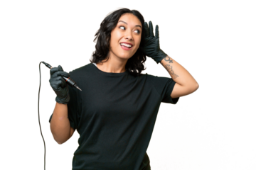 Tattoo artist Argentinian woman over isolated background listening to something by putting hand on the ear