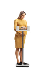 Pregnant woman weigning on a scale and looking down