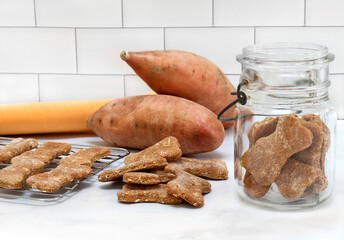 Sweet potato dog biscuits stacked, in jar and on cooling rack.