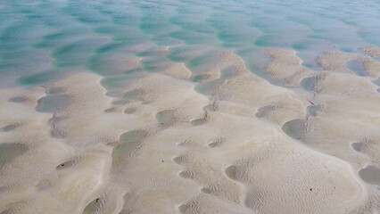 Wet sand at low tide, top view. Unusual sandy texture.