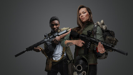 Shot of black man and white woman with rifles isolated on grey background.