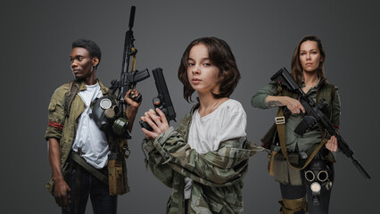 Portrait of adolescent girl with black man and woman on her sides in post apocalyptic setting.