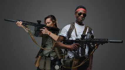 Studio shot of black macho man and woman survivors in post apocalyptic setting.