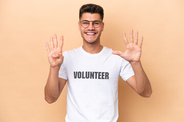 Young volunteer caucasian man isolated on beige background counting nine with fingers