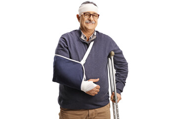 Mature man with a broken arm and bandage on head leaning on a crutch