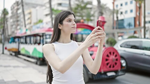 Young beautiful hispanic woman smiling confident recording video by smartphone at street