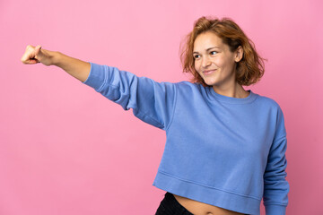 Young Georgian woman isolated on pink background giving a thumbs up gesture