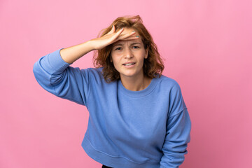 Young Georgian woman isolated on pink background looking far away with hand to look something