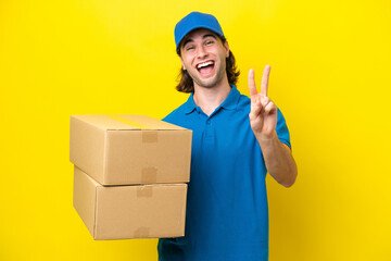 Delivery handsome man isolated on yellow background smiling and showing victory sign