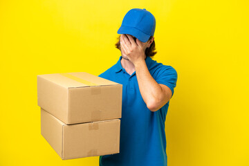 Delivery handsome man isolated on yellow background with tired and sick expression