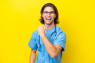 Young surgeon caucasian man isolated on yellow background celebrating a victory